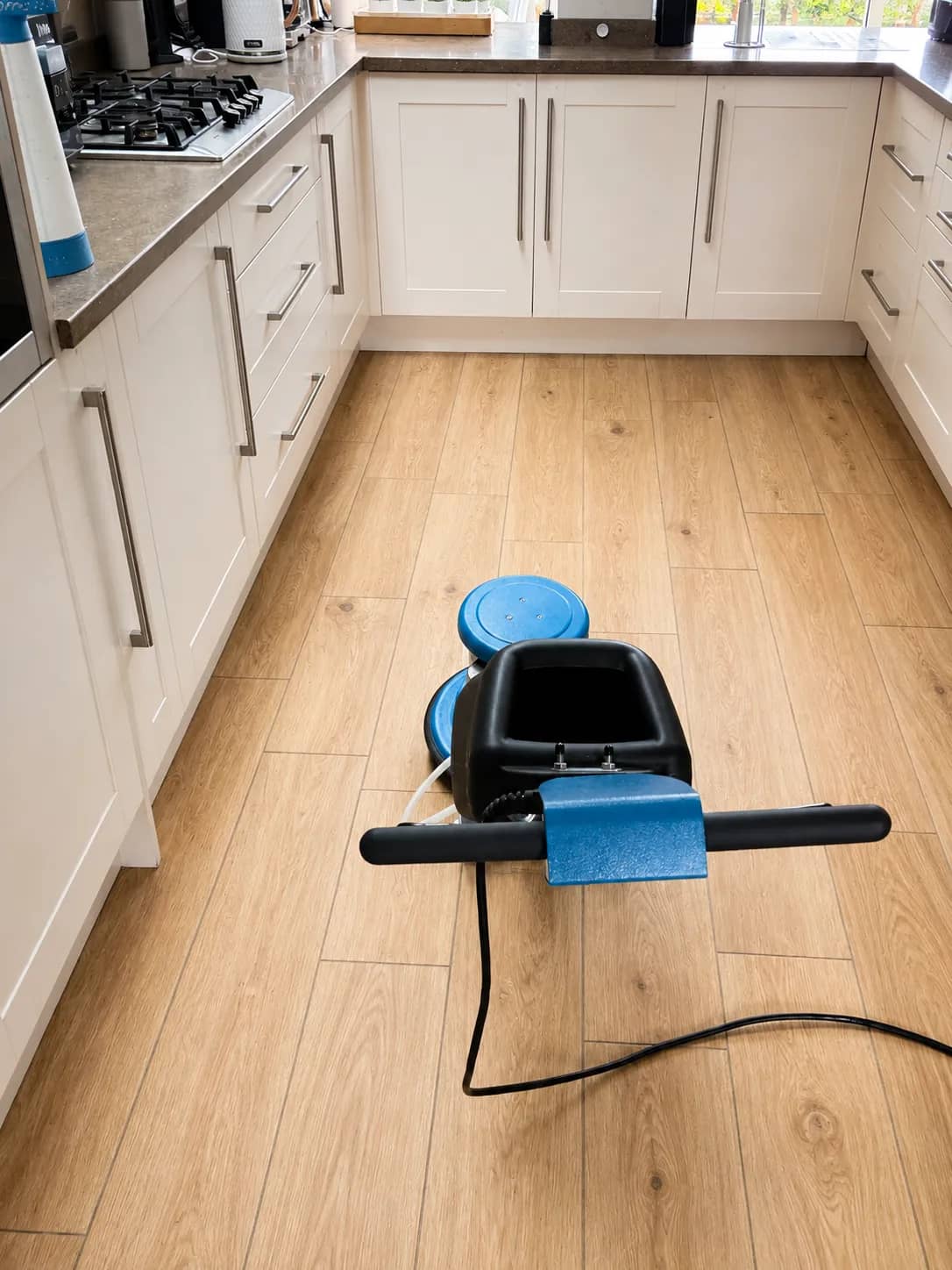 A kitchen floor being machine cleaned during a deep clean