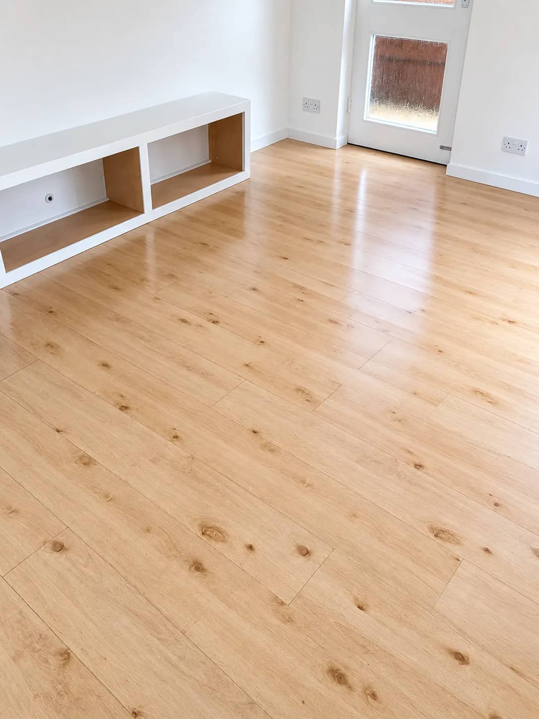A light oak laminate floor left clean in an open-plan living space.